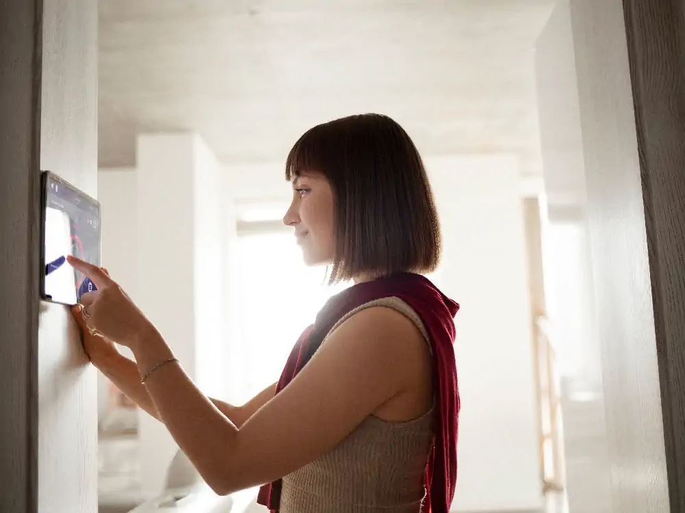smart-home-wolfsburg-elektriker-frau-navigiert-intelligentes-haus Frau bedient intelligente Steuerung zur Kommunikation mit dem Eigenheim für ein Smart Home System in Wolfsburg vom Elektriker